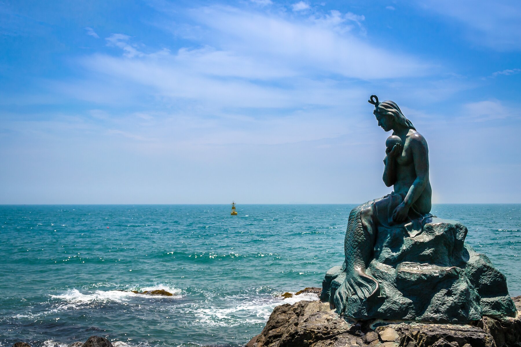 The bronze mermaid statue on the rocks at Busan's Sea World near Haeundae, overlooking the ocean