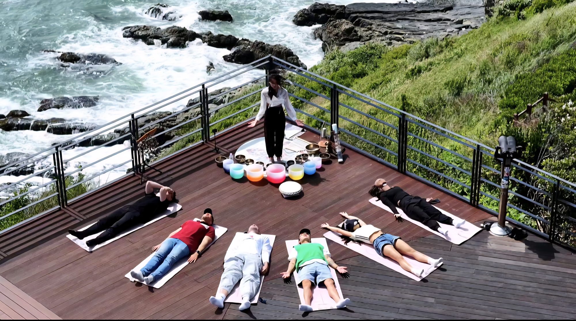 A private sound bath held on a deck above the coastline