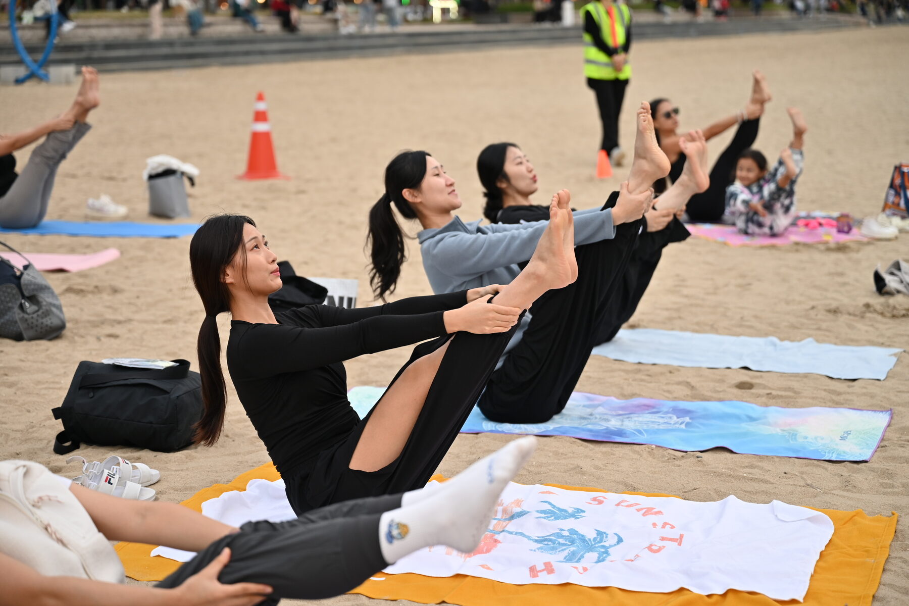 Close-up of a WellMi beach mat class stretching session