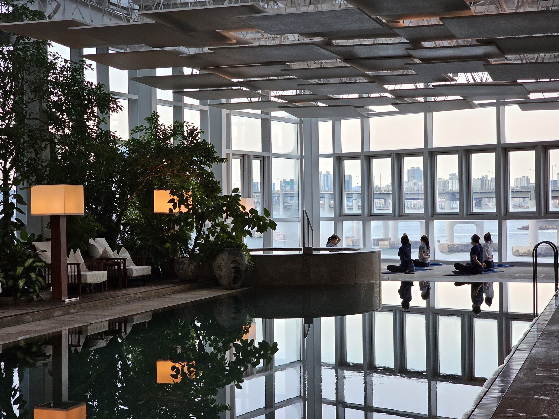 A WellMi meditation session beside an infinity pool overlooking the marina
