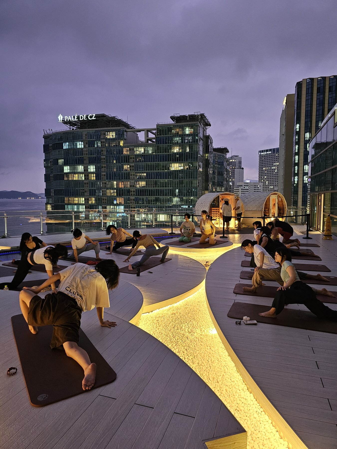 A WellMi rooftop yoga session at dusk, private saunas and the city skyline behind